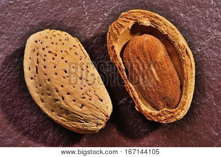 Almonds on stone background Almond nut in shell and shelled close up