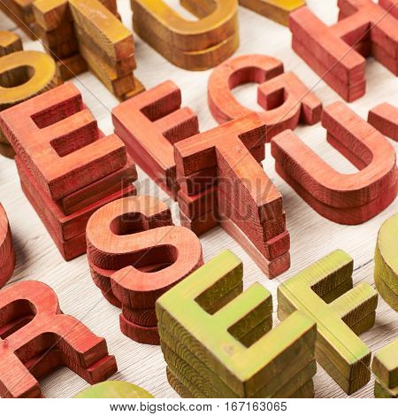 Surface coated with the multiple painted wooden block letters as an abstract backrop composition