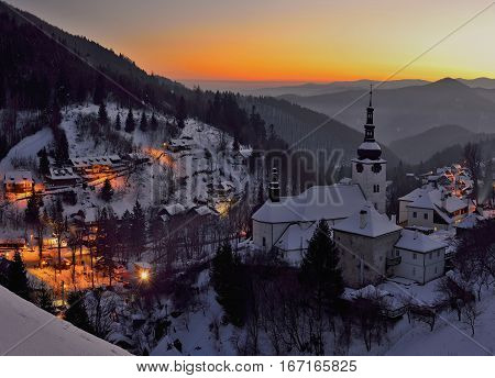 Sunset at winter in Slovakia. Old mining village. Historic church in Spania dolina.