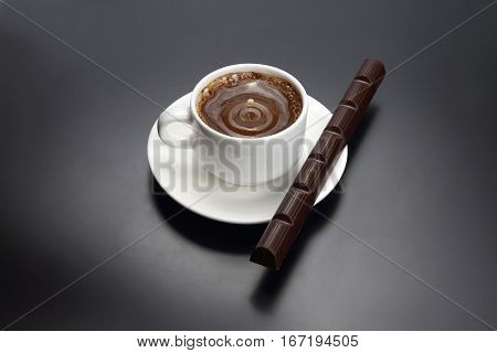 drop of milk falling in a white cup with black coffee