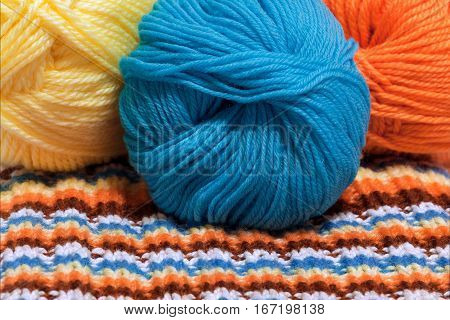 Colorful wool yarn and striped knitting fabric