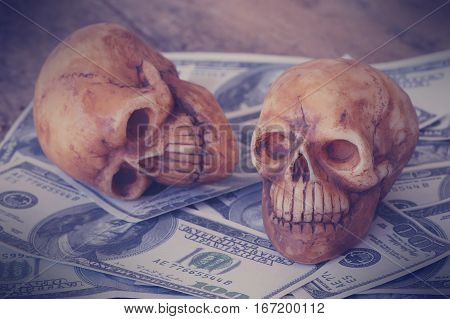 skull on bank note and coin money concept in work for money and death because of money