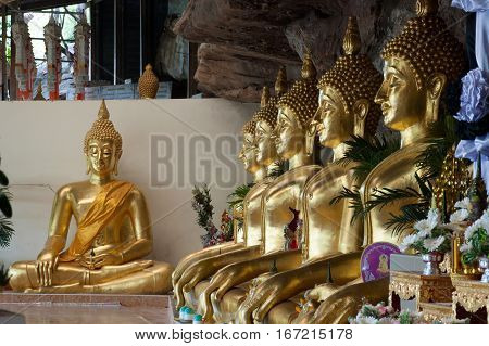 UBON RATCHATANI,THAILAND -JANUARY 17,2017 : Row of golden Buddha in the cave of Wat Tham Khuha Sawan temple is located on a high cliff above the river Mekong .Khong Chiam District , Ubon Ratchathani, Thailand.