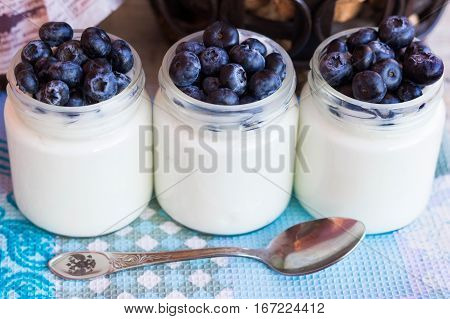 Homemade yogurt with blueberries in a glass jar