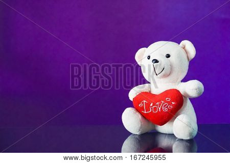 Teddy bear with heart sitting on the glass with  purple background. Get Taste Forever Valentine.