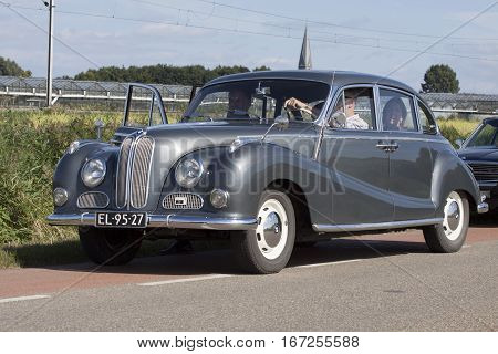 HOOGKARSPEL, THE NETHERLANDS - SEPTEMBER 18,2016:Silver vintage metallic BMW 502 from the year 1956 and  passenger in the car