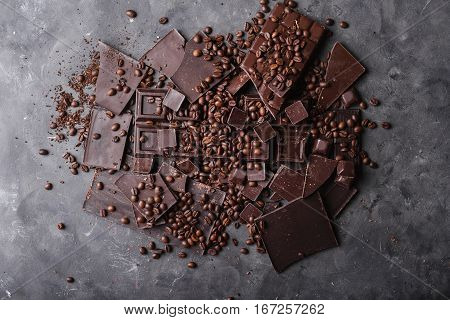 Coffee beans with chocolate dark chocolate. Broken slices of chocolate. Chocolate bar pieces. A large bar of chocolate on gray abstract background. Coffee beans. Sweet food photo concept. Copyspace