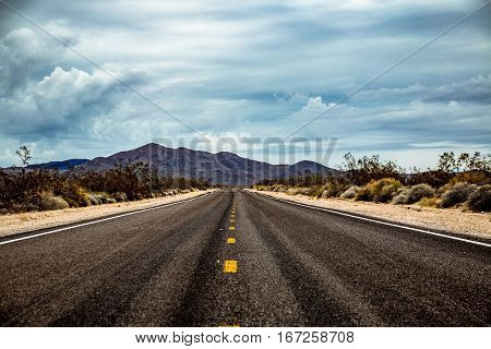 Road in the desert with mountains in the background, Mojave Desert, USA