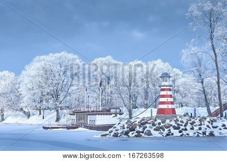 Navigation Lighthouse frozen water will shore frosted trees rime snow stone jetty pier tourist ship sunny day