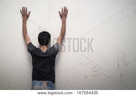 Man Show Hands Up Facing The Wall