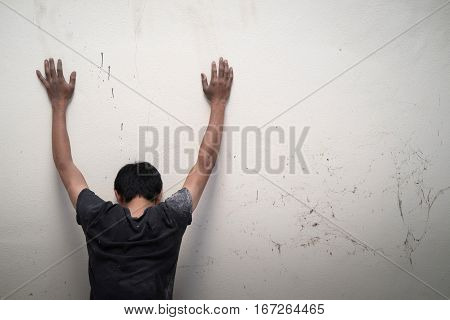 Man Show Hands Up Facing The Wall