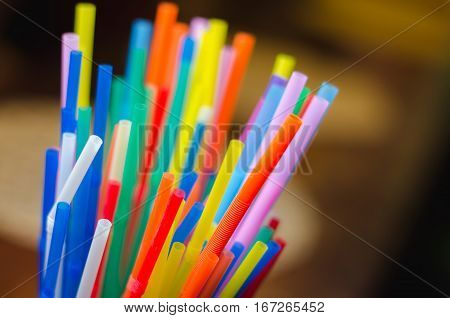 colorful drinking straws on the brown background