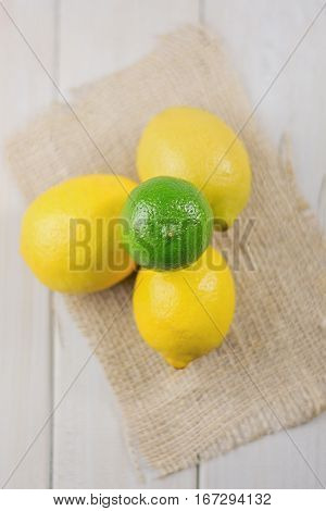Group of lemons and limes on a burlap cloth.