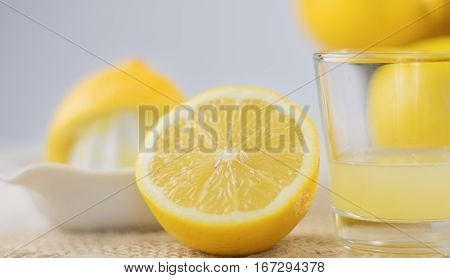 A glass of squeezed lemon juice and lemons around.