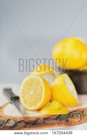 Cut lemon with knive on a wooden board.