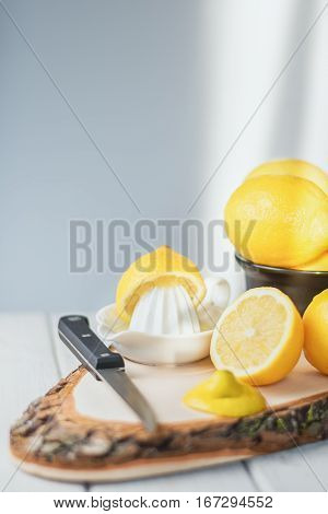 Cut lemon with knive on a wooden board.