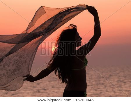 Mädchen mit Voile auf Sonnenuntergang Hintergrund.