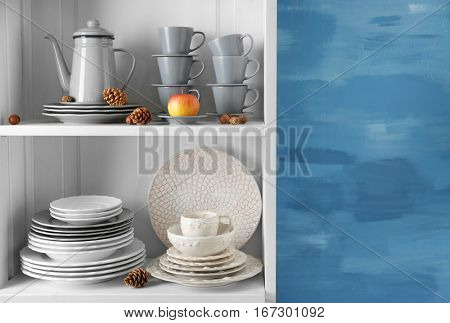 Different clean dishes in cupboard in the kitchen
