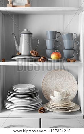 Different clean dishes in cupboard in the kitchen