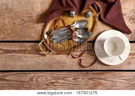Silverware with cup on wooden background