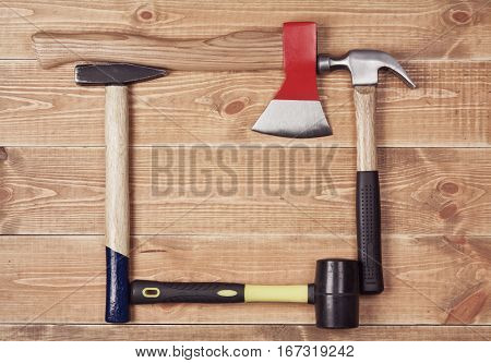 carpenter's hammer and ax on a wooden background