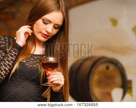 Woman Tasting Wine In Rural Cottage Interior