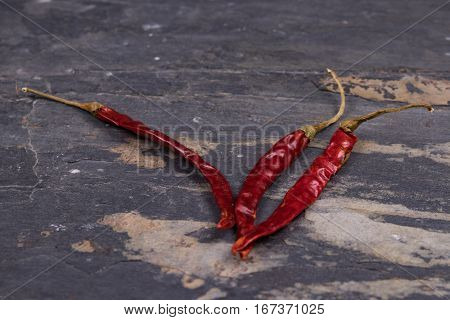 Dried red peppers on gray slate surface