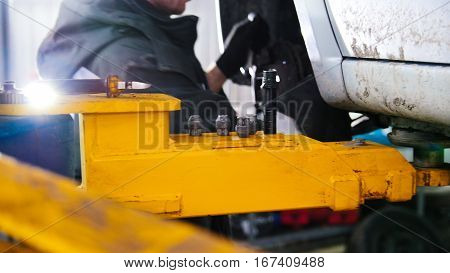 Car in auto service lifting for repairing, slider, close up