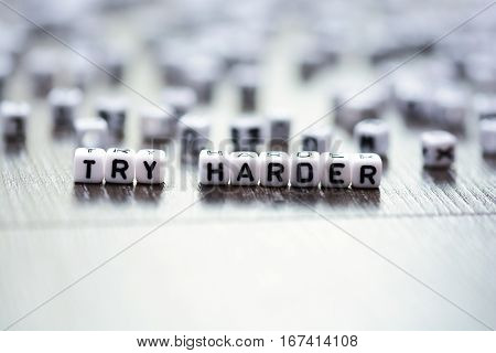 Try harder inspirational advice spelled by tiled letter beads