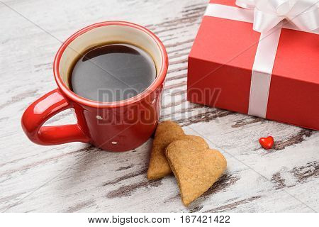 two red coffee cup, hearts cokies and gift box on wooden surface. Valentines day concept.