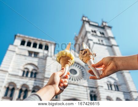 Two hands takes ice cream nearthe San Lorenco Cathedral