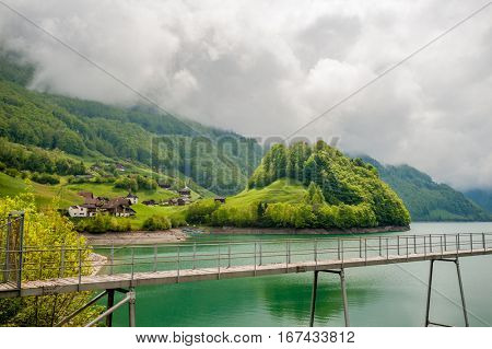 Beautiful emerald mountain lake Lungern in Switzerland under low clouds