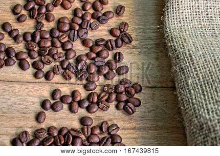 Coffee beans and burlap sack on a wooden table