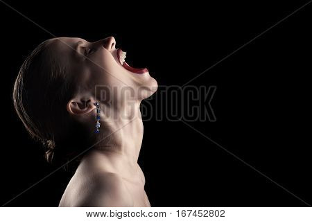 angry nude girl screaming up on black background
