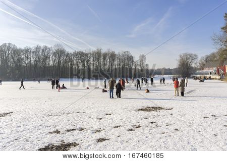 View on happy People on a frozen Lake. Different People on a sunny Winter Day.
Kuhsee in Winter. 
Augsburg - Germany