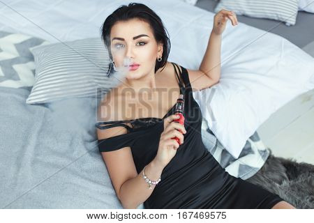 Woman sexy smoke in the room near the bed.