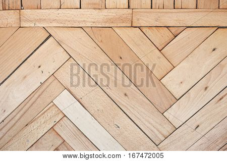 Close view on rich texture of old brushed and distressed wooden parquet floor made from many racks in herringbone and simple row pattern on top, abstract background image