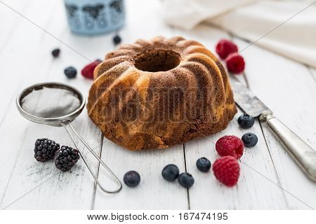 Cake. Marble cake cup of coffee powder sugar kitchen vintage utensil and fresh fruit berries.