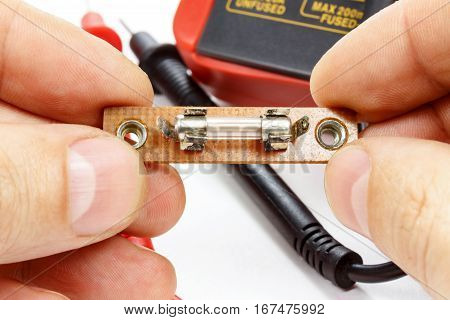 The fuse in the hands of an electrician on a white background