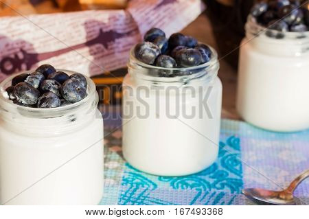 Homemade yogurt with blueberries in a glass jar