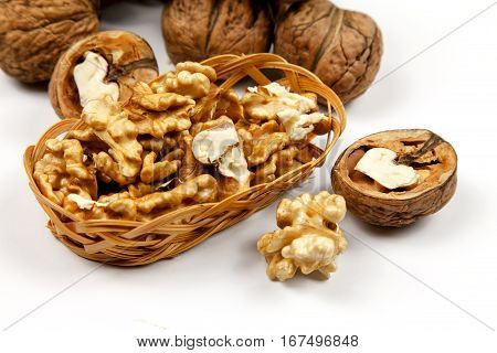 Whole walnuts and kernels on a table on a white background
