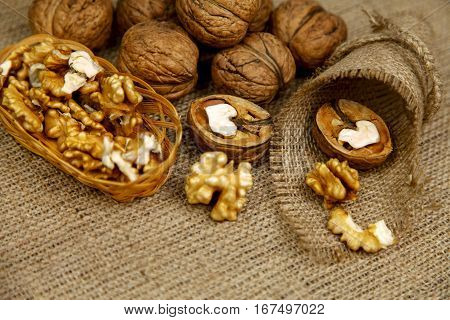 Whole walnuts and kernels on a table on sackcloth