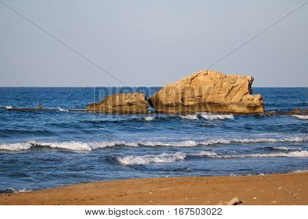 Rocky coast of the clear blue sea water.