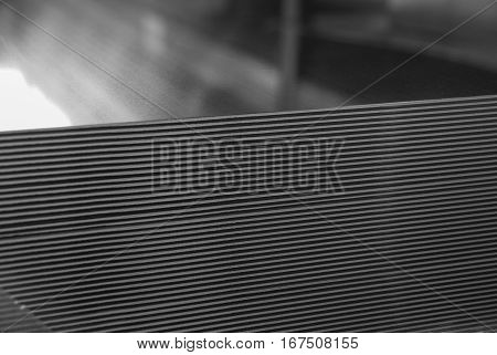 Aluminum sheet metal plates cut to length and stacked on a palette. Black and white