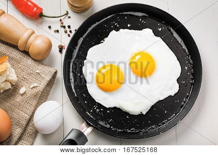 Delicious healthy simple breakfast meal made of eggs on a frying pan ready. Traditional homemade quick breakfast. International cuisine food. Top view.