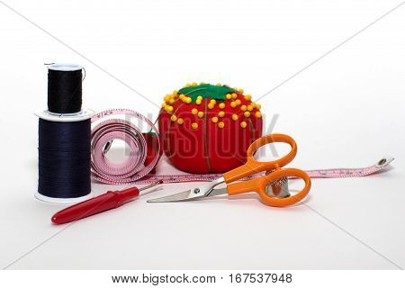 Assortment of sewing accessories isolated on white.