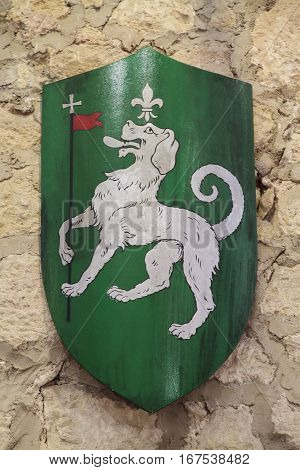 coat of arms of the last name domenech on a wall of stone as background