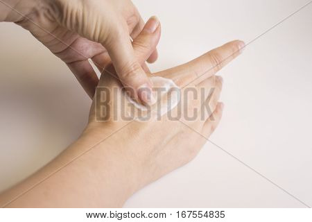 Hands of caucasian woman selfmassage with cream