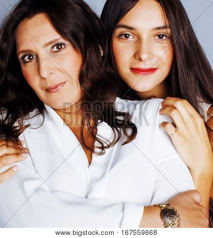 cute pretty teen daughter with mature mother hugging, fashion style brunette makeup close up, real happy family