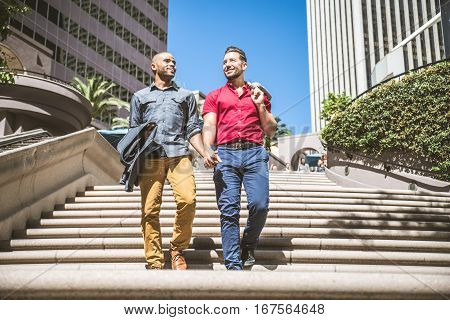 Homosexual couple at a romantic date outdoors - Multi-ethnic gay couple in love flirting and having fun